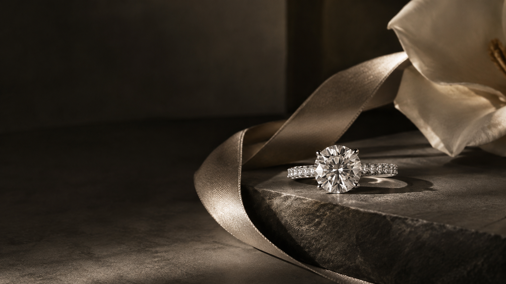 Close-up of a brilliant-cut diamond solitaire engagement ring on a white marble surface — DETARA KISS editorial